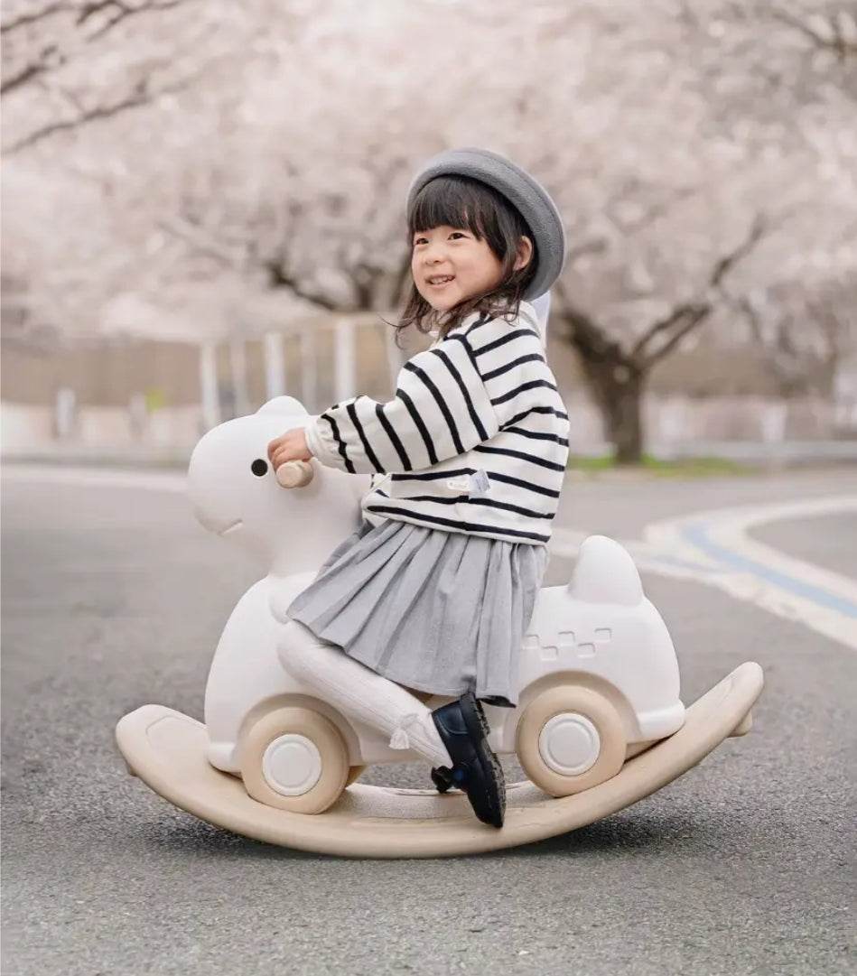 Kind playing on beige Hobbelfiguur Loopwagen Basic rocking walker toy outdoors